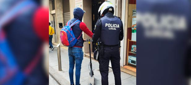 Un agente de la Policía Local detiene a un usuario de patinete eléctrico para verificar el cumplimiento de las normativas de circulación